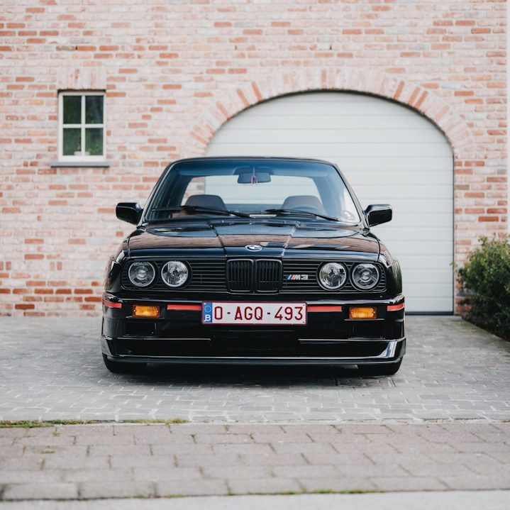 BMW E30 vor Garage – Beratung zur Oldtimerzulassung inkl. Rückrüstung durch GRS & SONNE